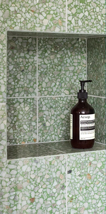 Green shower wall with terrazzo tiles